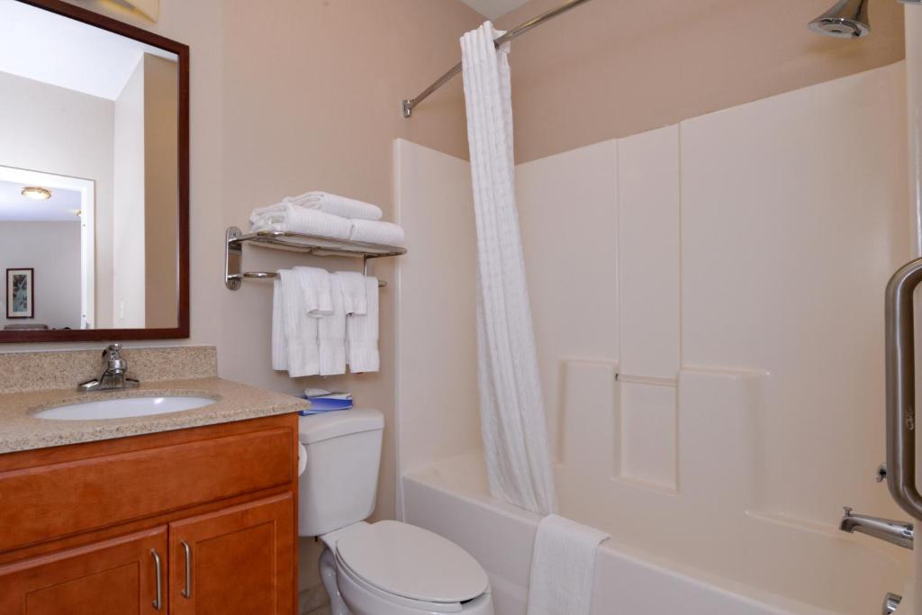 a white toilet sitting next to a bath tub at Candlewood Suites Boise - Towne Square, an IHG Hotel in Boise