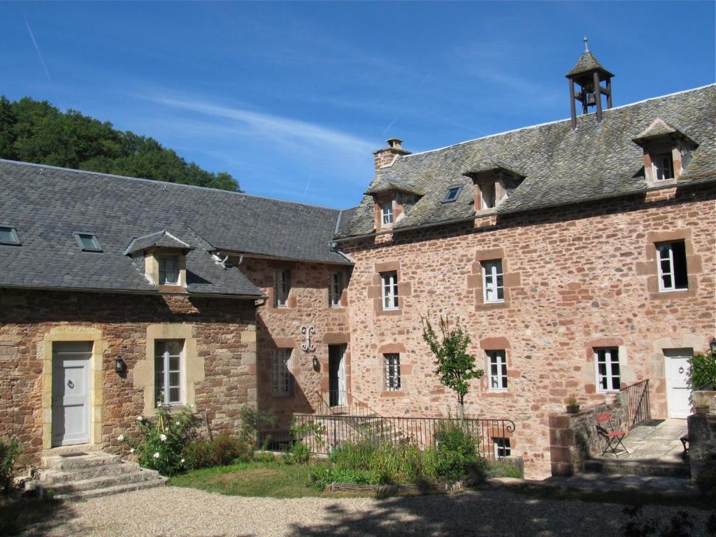 an old brick building with a gray roof at Domaine d'Armagnac in Bessuéjouls