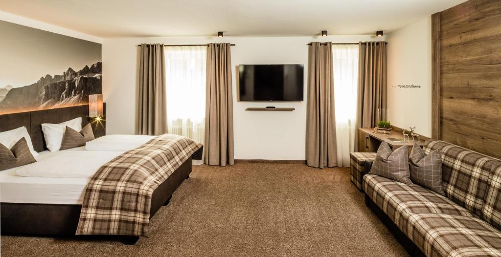 Posteľ alebo postele v izbe v ubytovaní Hotel Touring Dolomites