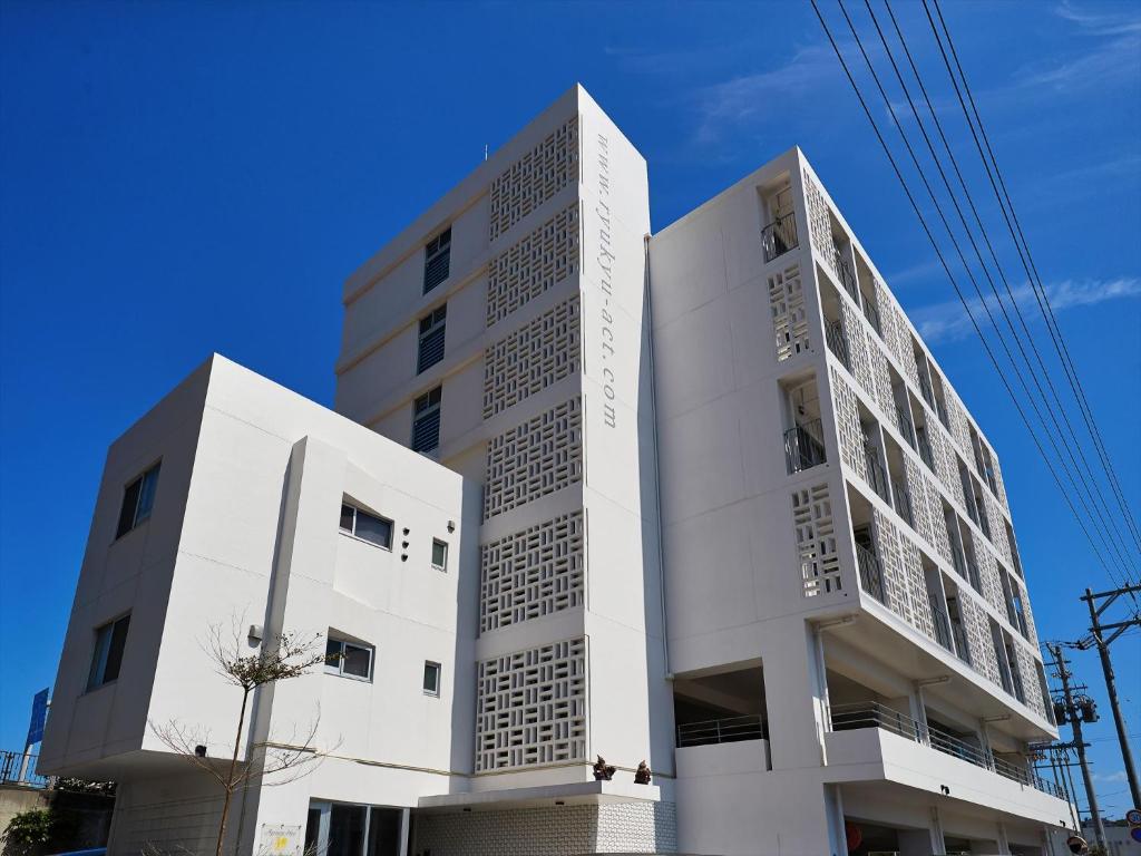 ein weißes Gebäude mit zwei Türmen in der Unterkunft アルセ琉球ハーバーステイ in Urazoe