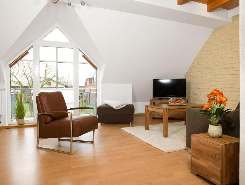 een woonkamer met een stoel en een tv bij Appartements Am Reiterhof Seepferdchen in Timmendorf