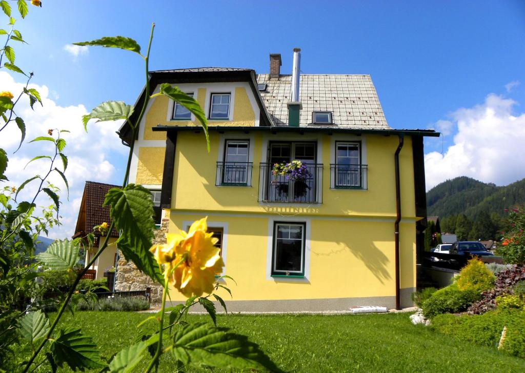 una casa amarilla con una flor delante en Landhaus Semmering, en Semmering