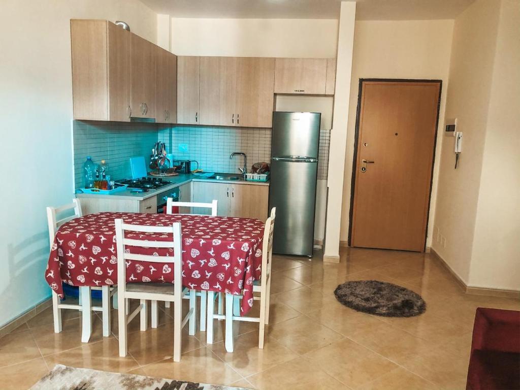 eine Küche mit einem Tisch mit Stühlen und einem Kühlschrank in der Unterkunft MiMi's Beach Apartment in Vlorë