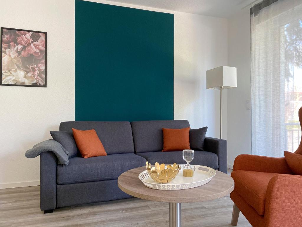 sala de estar con sofá azul y mesa en Boardinghouse Living28 Kaarst en Kaarst