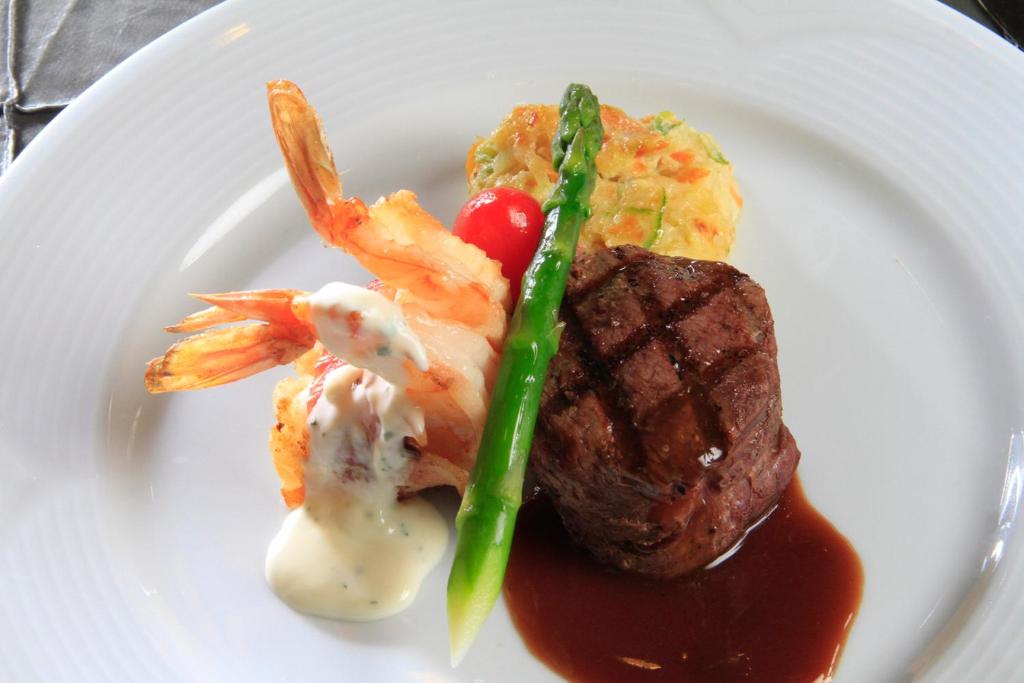 a plate of food with steak and shrimp and sauce at Holiday Inn Monterrey-Parque Fundidora by IHG in Monterrey