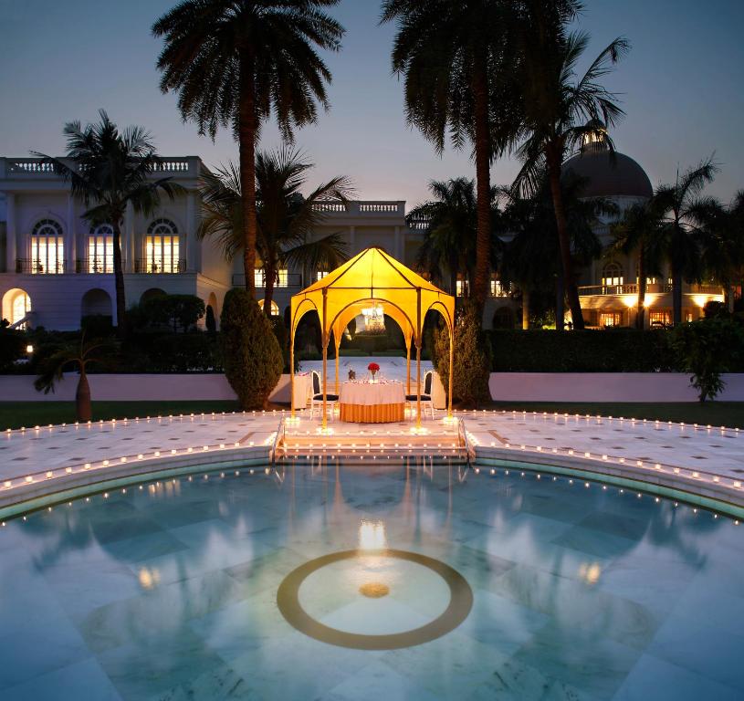 einen Pool mit einem Pavillon vor einem Gebäude in der Unterkunft Taj Mahal Lucknow in Lucknow