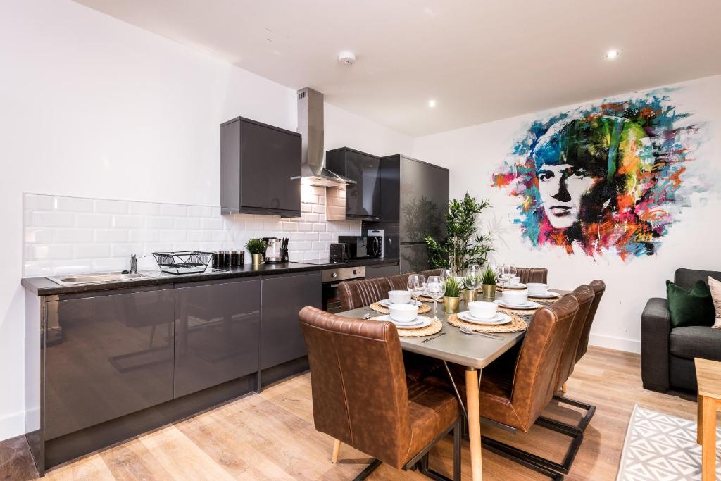 uma cozinha e sala de jantar com mesa e cadeiras em SGT Peppers Mathew Street Apartments By Happy Days em Liverpool