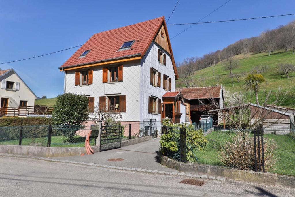 uma grande casa branca com um telhado vermelho em Spacieux et confortables gîtes à proximité randonnées, lacs, ski nature em Sondernach