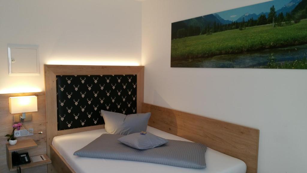 a bedroom with a bed and a painting on the wall at Landhotel Böld Oberammergau in Oberammergau