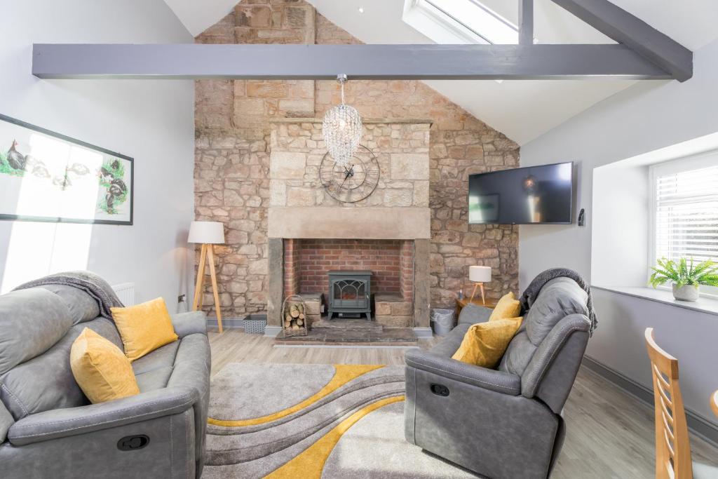 sala de estar con 2 sofás y chimenea en Host & Stay - Lavender Cottage, en Bamburgh
