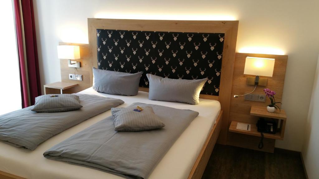 two beds in a room with two pillows at Landhotel Böld Oberammergau in Oberammergau
