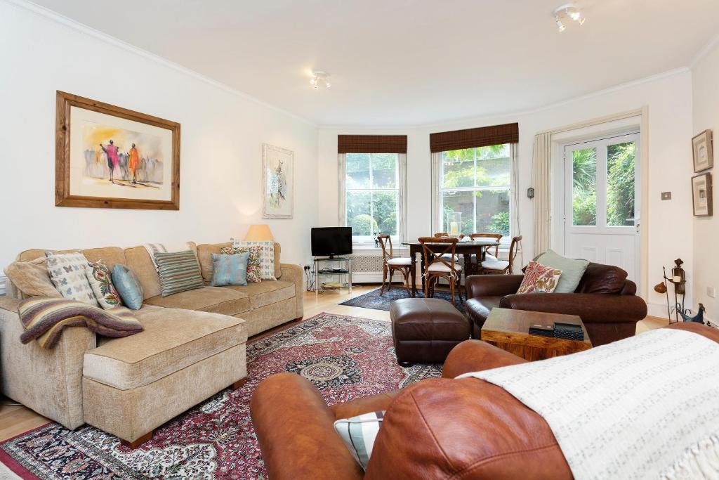 a living room with a couch and a table at Veeve - South Kensington Garden Apartment in London