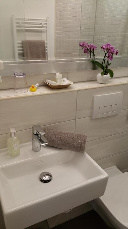 a bathroom with a sink with a vase of flowers at Landhotel Böld Oberammergau in Oberammergau
