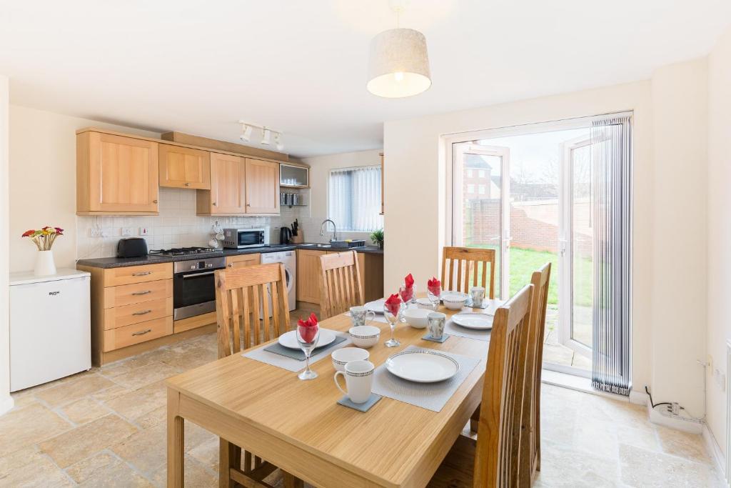 a kitchen and dining room with a wooden table at 5 Bedroom Home Stay in Wolverhampton