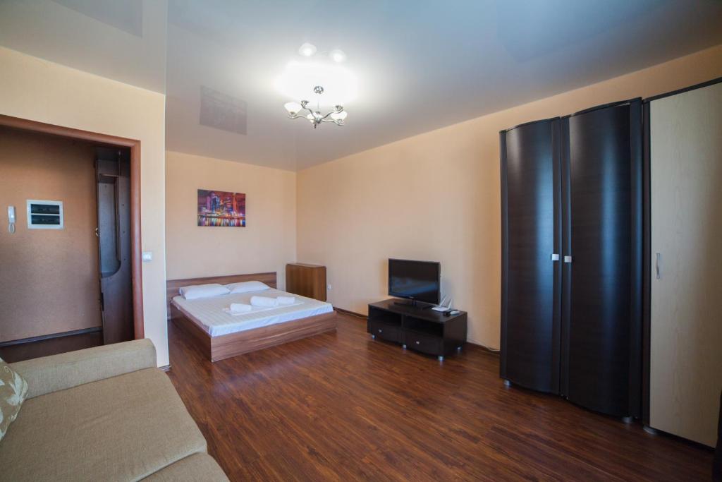 a living room with a bed and a large refrigerator at Apartments KSGM London at Gamarnika 6A in Khabarovsk