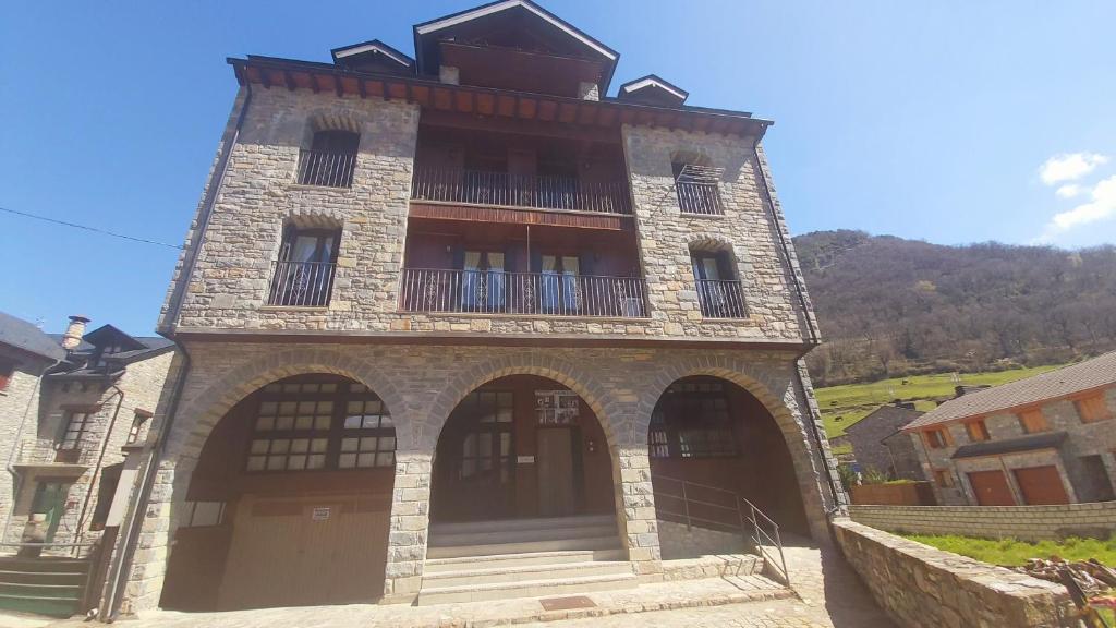 a large brick building with a balcony on top of it at Santa Cruz in Broto