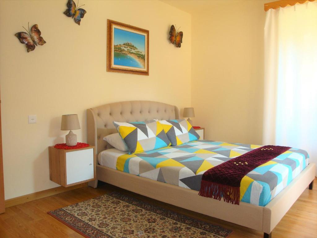 Un dormitorio con una cama con almohadas de colores y una ventana en Casa Lucini, en Campascio