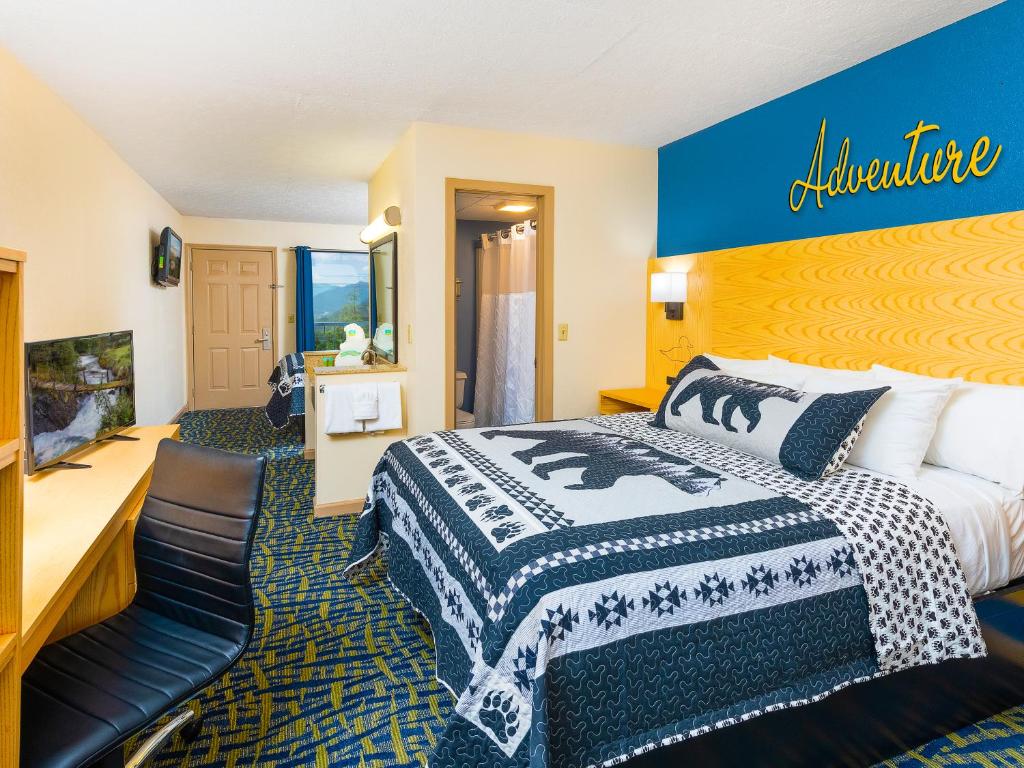 a hotel room with a bed and a sign on the wall at Creekstone Inn in Pigeon Forge