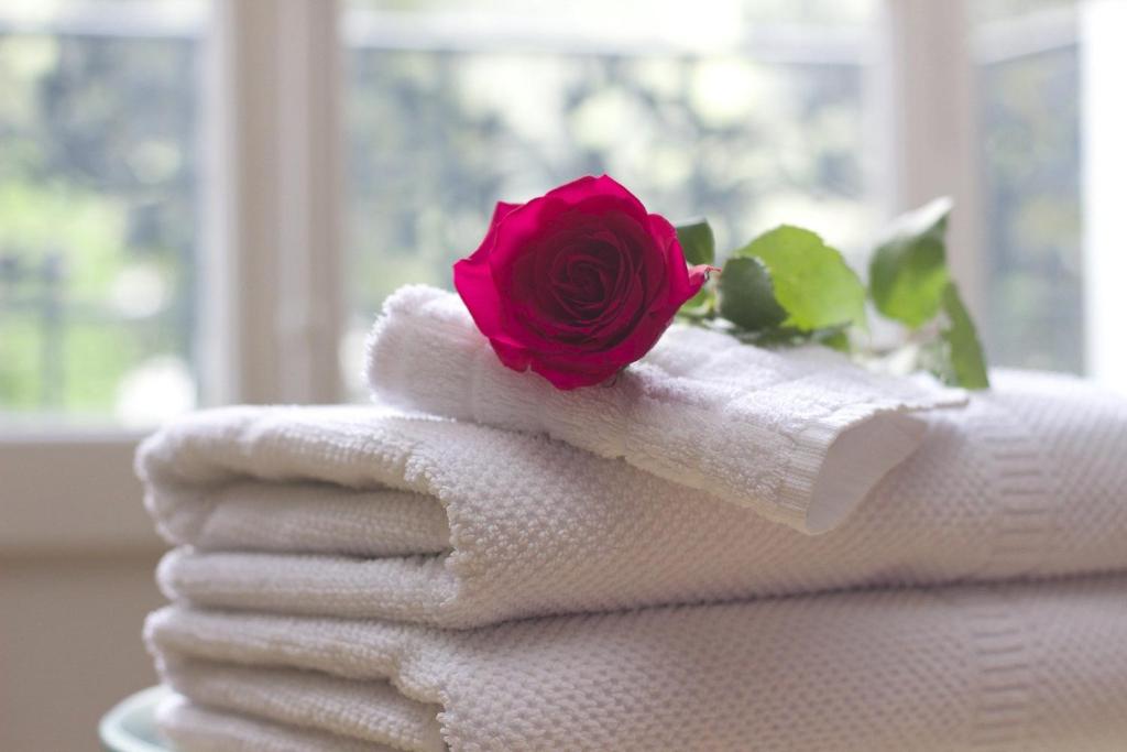 a rose on top of towels with a flower on top at Hotel Zajazd Mazowsze in Słupno
