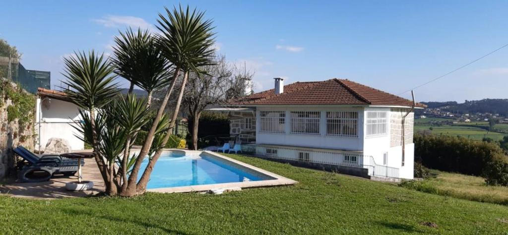 a house with a swimming pool next to a palm tree at Casa S. Félix in Arcos