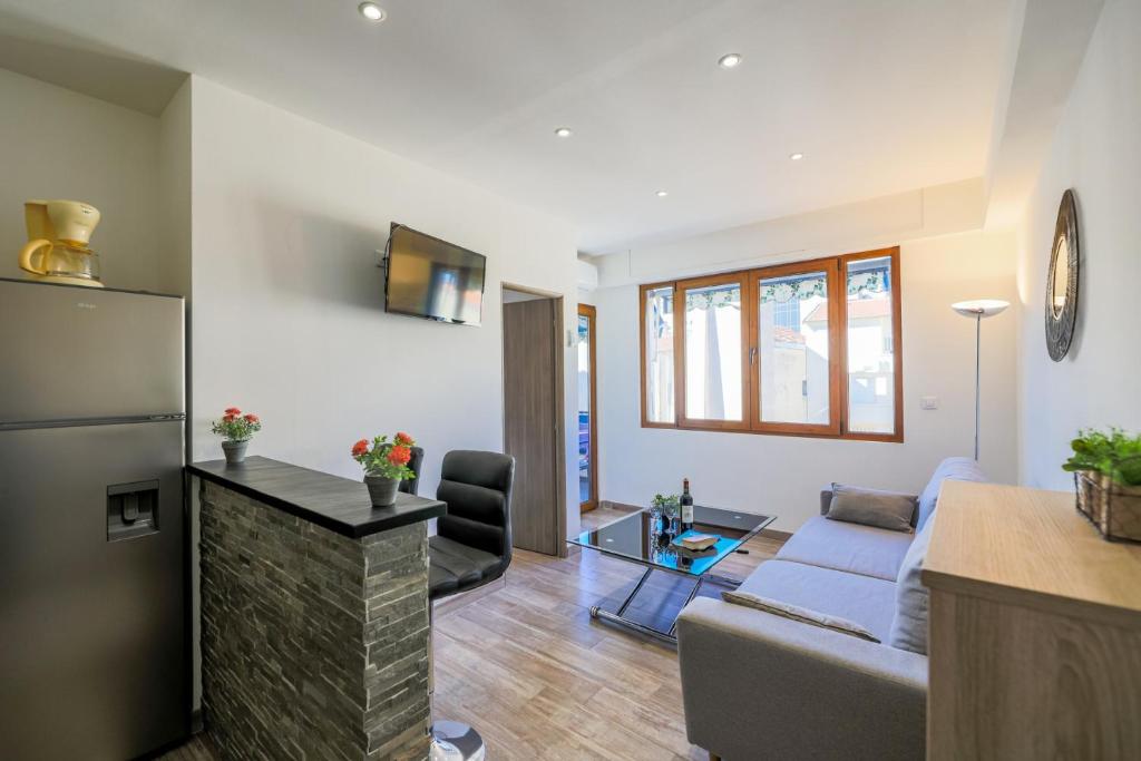 Il dispose d'une cuisine et d'un salon avec un canapé et un réfrigérateur. dans l'établissement MASSENET PIETONNE AP4196 by Riviera Holiday Homes, à Nice