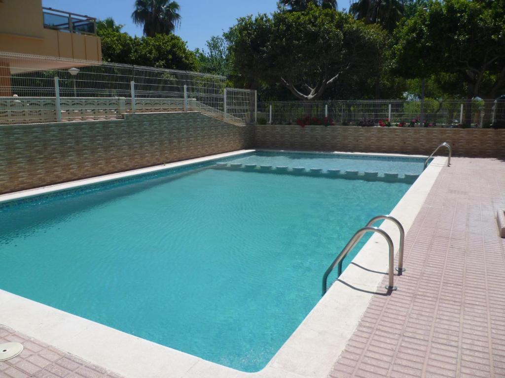 a large blue swimming pool with a brick wall at MARIVENT-A, 10-30 in Cullera