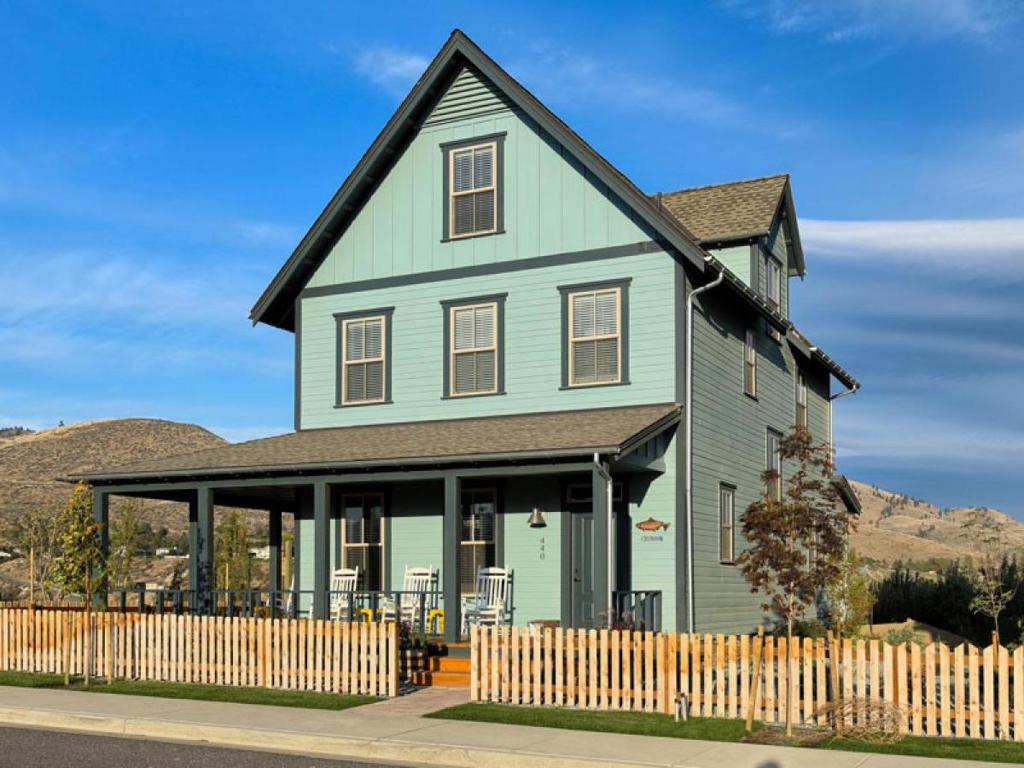 a green house with a black roof at Chinook & Carriage House #2 in Chelan