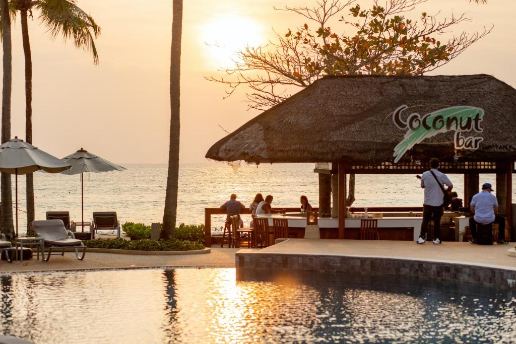 a group of people standing around a pool at a resort at Katathani Phuket Beach Resort - SHA Extra Plus in Kata Beach