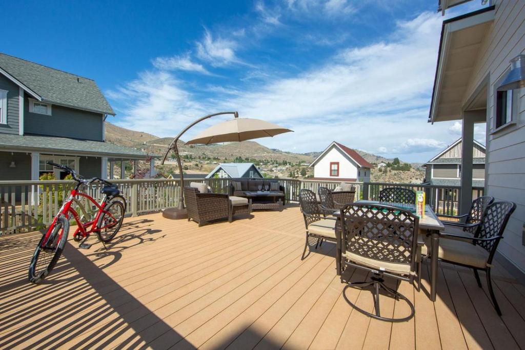 a deck with a table and chairs and an umbrella at Lake Life #17 in Chelan