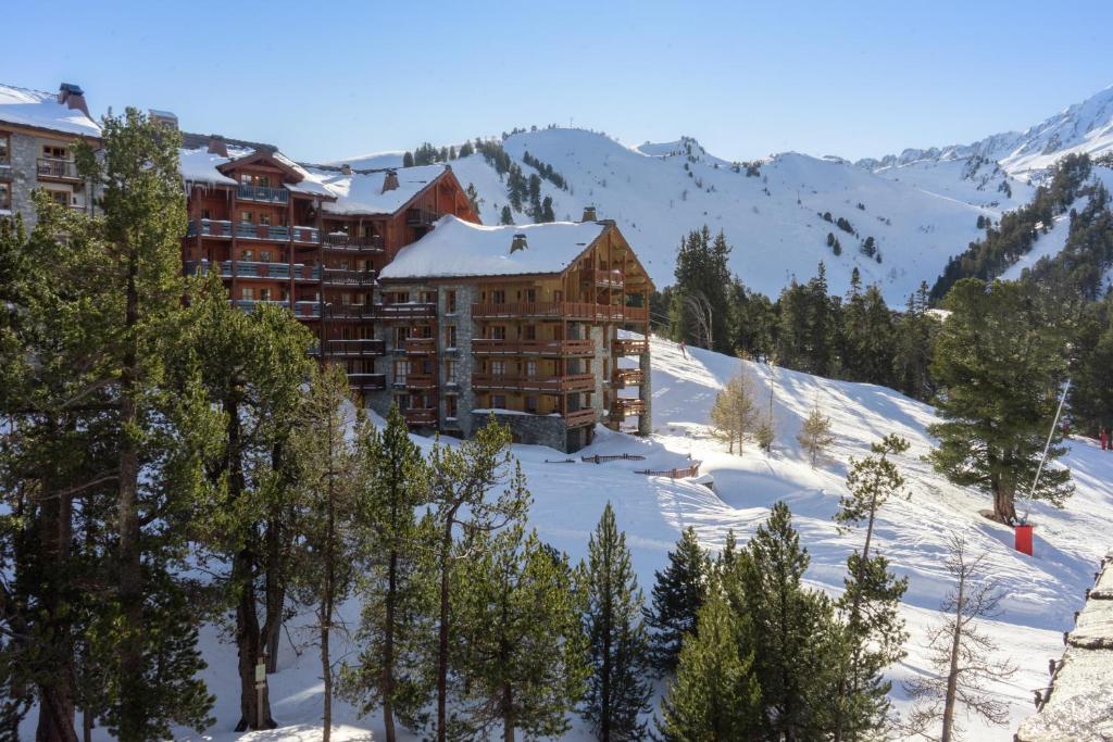 a hotel in the mountains with snow on the ground at Arc1950 Auberge Jérôme in Bourg-Saint-Maurice