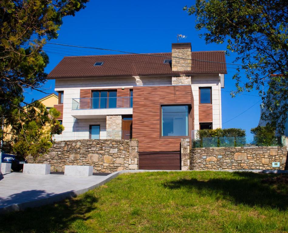 uma casa com uma parede de pedra em CASA FEITIÑA: vistas al mar, moderna y funcional em Ilha de Arousa