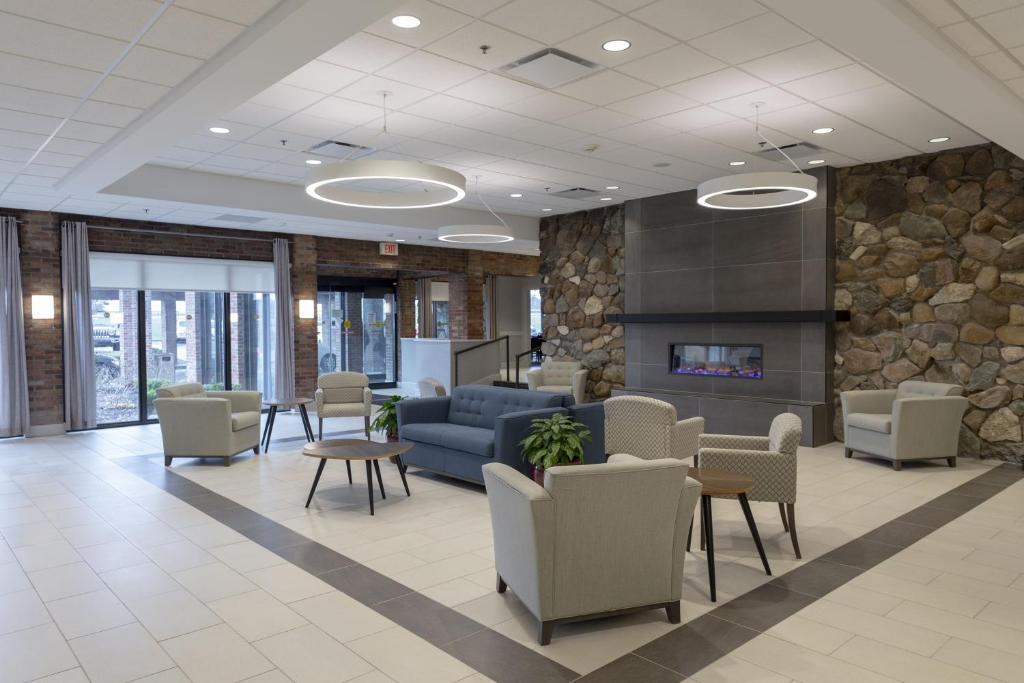 a lobby with chairs and a couch and a fireplace at RIT Inn & Conference Center in Henrietta