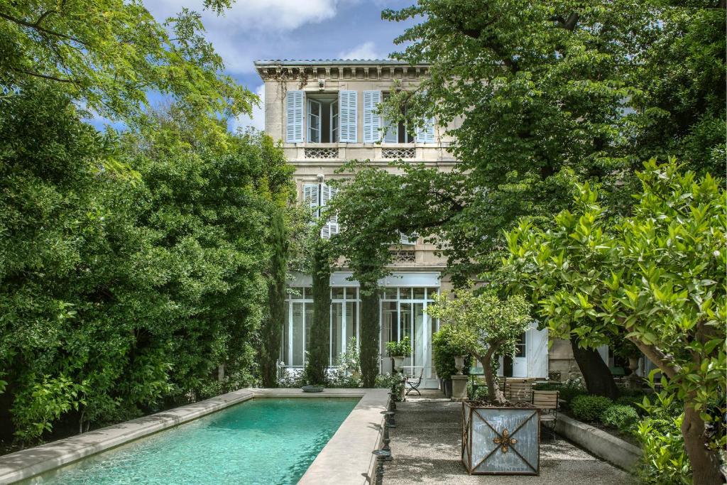 une maison avec une piscine en face d'un bâtiment dans l'établissement L'Hôtel Particulier, à Arles