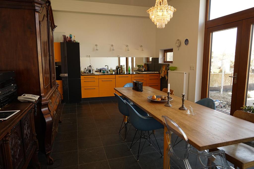 cocina con mesa de madera y sillas azules en Stille, Aussicht und Kunst am Archäologischen Park, en Xanten