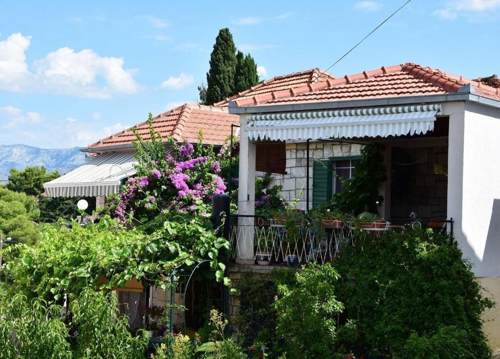 dom z balkonem i fioletowymi kwiatami w obiekcie Apartments Kat - 80 m from beach w mieście Splitska