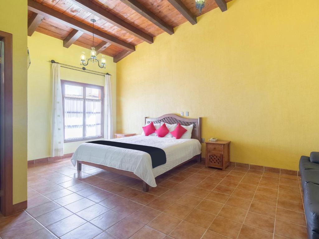 - une chambre avec un lit doté d'oreillers rouges dans l'établissement Hotel Jardín de Tereza, à Comitán de Domínguez