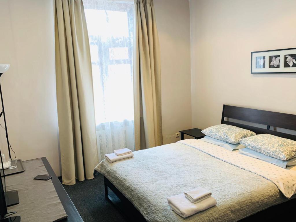 1 dormitorio con 1 cama con 2 toallas en ILIAN Hostel, en Moscú