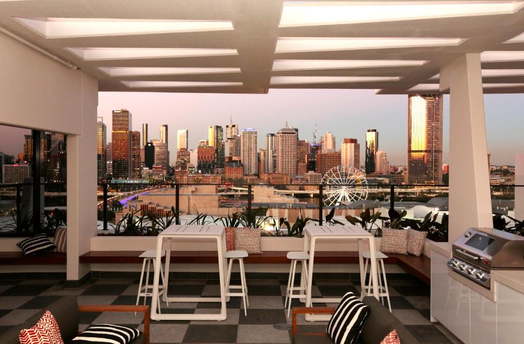 a balcony with chairs and a view of a city at Opera Apartments South Brisbane in Brisbane