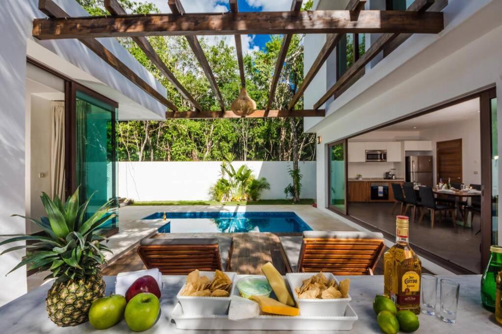eine Villa mit einem Pool und einem Tisch mit Speisen in der Unterkunft Tranquil villa with pool and chef services 4BR 8ppl in Tulum