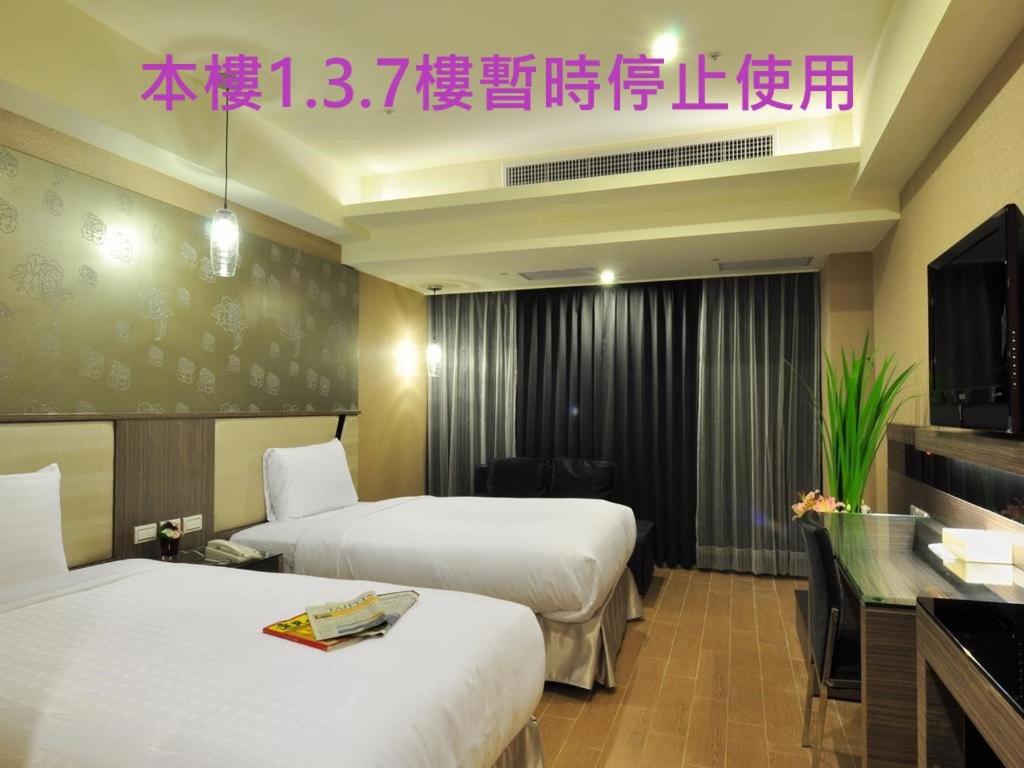 a hotel room with two beds and a television at Goodness Plaza Hotel in Taishan
