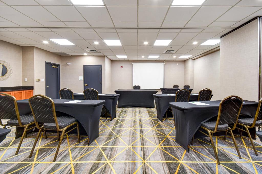 a conference room with tables and chairs and a screen at Holiday Inn Allentown-Bethlehem by IHG in Allentown