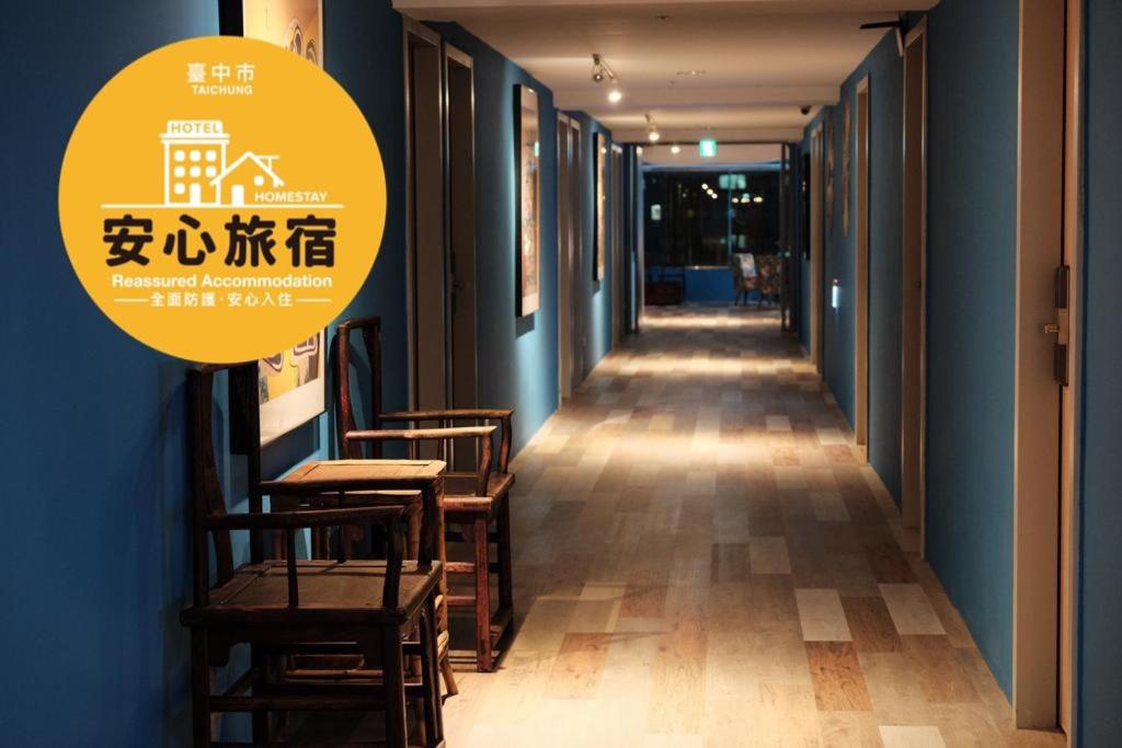 a corridor with chairs and tables in a building at Happy Inn in Taichung