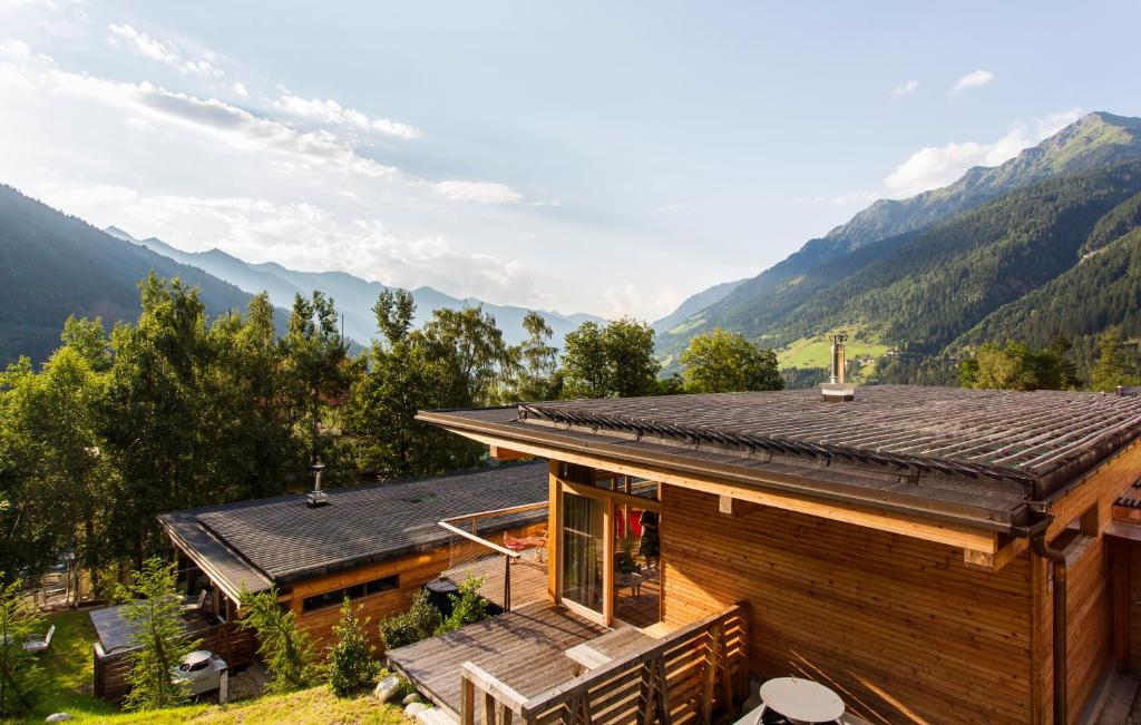 a log house with mountains in the background at Alpenlofts in Bad Gastein