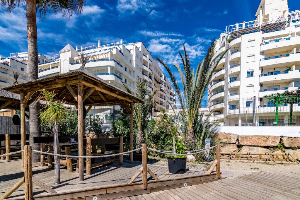 a wooden gazebo in front of a building at Banana Beach in Marbella
