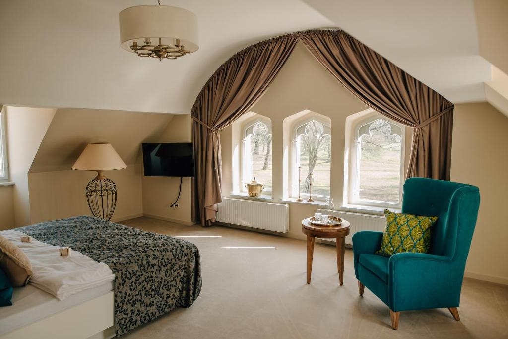 ein Schlafzimmer mit einem Bett, einem Stuhl und einem Fenster in der Unterkunft Cavalierhaus Branitz in Cottbus