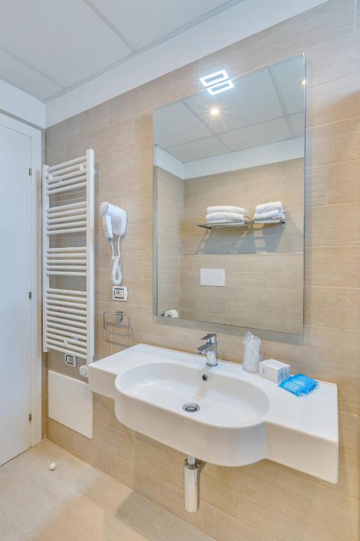 a bathroom with a sink and a mirror at Hotel Ambassador in Caorle