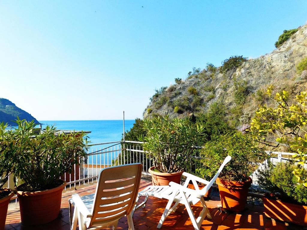 twee witte stoelen op een terras met uitzicht op de oceaan bij Attico vista mare in Levanto