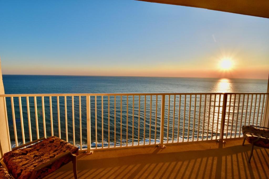 a balcony with a view of the ocean at sunset at Amazing Sunset Oceanfront Condo in Panama City Beach