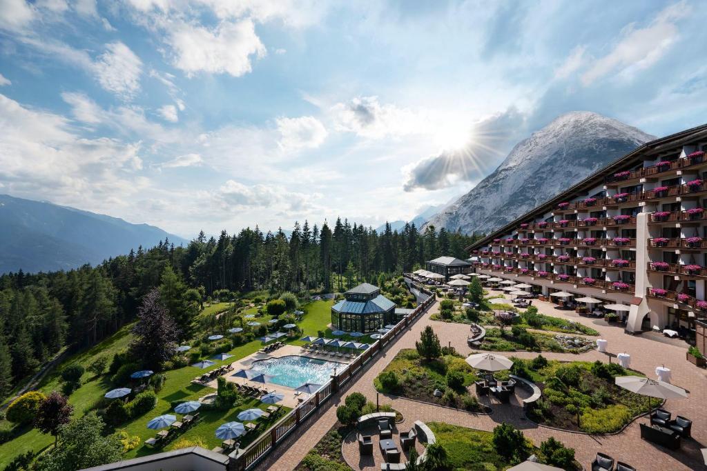 an aerial view of a resort with a pool and a mountain at Interalpen-Hotel Tyrol in Telfs-Buchen