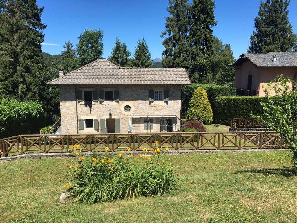 a house with a wooden fence in a yard at Contessa Pace - Luxury flat in Selvino